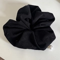 Dettaglio di un elastico in velluto a coste nero con ciondolo a perla bianca decorato - Scrunchie / Riga Nera