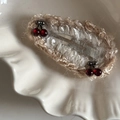 Dettaglio di un fermaglio per capelli all'uncinetto con perline a ciliegia - Clip Ciliegia Goccia Bordo Tè al Latte