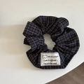 Dettaglio dell'elastico per capelli a quadretti scuri con etichetta a forma di orso - Scrunchie con Patch a Righe Blu