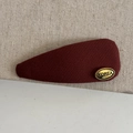 Detalle macro de pinza de pelo de sarga rojo vino con logotipo metálico Korea dorado - Pinza para el cabello de gota de agua roja vino