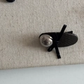 Detailed macro view of black lychee leather hair clip with silver bead and ribbon bow - Khaki PU Oval Style (Pearl Bow)