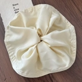Chic cream white oversized pleated satin scrunchie on dark wooden surface backdrop - Off White