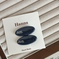 Zweiteiliges Set marineblauer Denim-Haarspangen mit silbernem Logo auf weißer Karte - Ovaler Stil