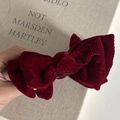 Close-up of a burgundy velvet bow hair clip with sparkling silver glitter finish - Burgundy