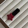 Detailansicht der roten Stern-Haarspange mit goldener France Handmade Prägung auf Stoff - Weinroter Stern Schwarzer Clip