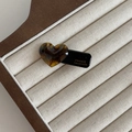 Detailansicht der Haarspange mit bernsteinfarbenem Herz und goldenem Schriftzug auf Basis - Schildpatt Herz Schwarzer Clip