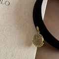Detailansicht eines goldenen Vintage-Ohrrings mit filigranen ethnischen Schnitzereien - Schwarzes Beflocktes Stirnband Mit Goldanhänger