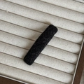 Close-up of black fuzzy fabric hair clip featuring soft plush texture on beige tray - Black Rectangular Clip