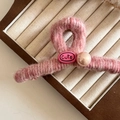 Primer plano de pinza para el pelo de peluche rosa con etiqueta y detalle de perla - Estilo Peluche Rosa / Rosa