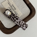 Dettaglio della molletta floreale marrone con perle bianche su vassoio di legno - Stile Floreale Rettangolare Perla