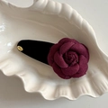 Dettaglio del fermaglio per capelli a camelia bordeaux con base in velluto e charm Love - Fiore Rosso Goccia Fioccata Nera