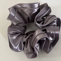 Detailed view of dark grey satin scrunchie with silky luster and pleated texture - Purple