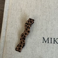Detail of leopard print wavy acetate duckbill hair clip on textured beige fabric - Leopard Wave Duckbill Clip