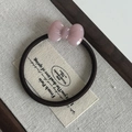 Detailed close-up of a pink resin bow elastic hair tie on a rustic linen background - Pink Bow Hair Tie