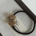 Macro shot of khaki acetate bow decoration on a durable brown elastic hair tie - Coffee Bow Hair Tie