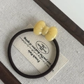Macro detail of yellow resin bow on a high-elasticity dark brown braided hair tie - Yellow Bow Hair Tie