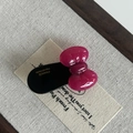 Detailed macro view of a handmade acetate bow hair clip with golden France engraving - Rose Red Bow Black Hair Clip
