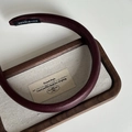 Detail of burgundy faux leather headband featuring a white HANDMADE label on inner tip - Wine Red (2cm Headband)