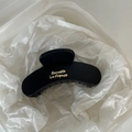 Close-up of matte black hair claw clip featuring golden Barrette La France lettering - Black
