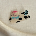 Détail de la pince à cheveux chat caramel avec chapeau rose et queue bleue sur beige - Style Chat Taches Noires (10#)