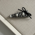 Dettaglio della clip per capelli a scacchi con perle a cuore e un fiocco in nastro nero - Fermaglio a Triangolo Plaid Bianco e Nero Con Perla