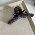 Detail of plush taupe claw clip with leather bow on a minimalist fabric background - Large / Gray