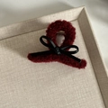 Detail of dark red plush hair claw clip with black leather bow and gold spring mechanism - Small / Burgundy