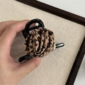 Vintage haarklem met luipaardprint roos van zwart hars in de hand gehouden - Luipaard Roos Zwarte Haarklem
