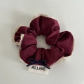Vue macro d'un chouchou à carreaux bordeaux avec bordure en dentelle et noeud - Rouge