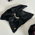 Dettaglio di elastico per capelli in pelle nera con ciondolo a cuore dorato e incisione - Elastico Aquilone Nero #3