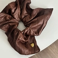 Dettaglio di un elastico per capelli in pelle marrone con ciondolo a cuore dorato e incisione - Elastico Aquilone Caffè #4