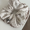 Detail of beige scrunchie with brown embroidery, crochet edge and bow charm - Black Bow / White Scrunchie