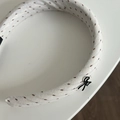 Detail of cream fabric headband with brown dotted pattern and black bow accessory - Black Bow / White Headband