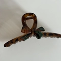 Dettaglio della grande pinza per capelli tartarugata con design a fiocco e scritte oro - Grande molletta per capelli con fiocco