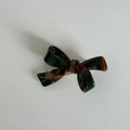 Detailed macro view of an acrylic bow hair claw clip with a dark tortoise pattern - Hair Bow