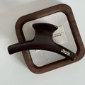 Détail de la pince à cheveux marron chocolat brillant avec texte doré Barrette La France - Hanger Shape Style