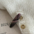Détail d'une pince à cheveux à carreaux roses fixée sur un tricot blanc à boutons marron - Pince Ovale Longue Rose Noire Carreaux (4#)