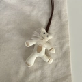 Détail d'un pendentif ours en tricot fait main avec col en dentelle et broderie brune - Ours en Dentelle Blanc Cassé (10#)