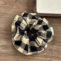 Elastico per capelli con motivo a scacchi caffè e beige su sfondo di legno scuro - Classico Quadri Neri Tè al Latte