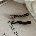 Detalle de pinzas para el pelo con estampado de leopardo, perla marrón y texto dorado francés - Par de Pinzas de Onda Marrón Leopardo