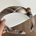 Detail eines gepolsterten braunen Stirnbands mit Karomuster, Knopf und Perle - Haarreif / Kaffee Kariert Haarreif - Kaffee Perle
