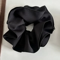 Detalle de un coletero de tela negra con pliegues de alta densidad y textura tejida - Negro
