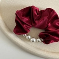 Elegant wine red velvet scrunchie with pearls on a textured beige display tray - Flocked Scrunchie Pearl / Burgundy