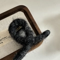 Dettaglio ravvicinato della pinza per capelli in peluche grigio scuro con molla dorata - Nero Piccolo