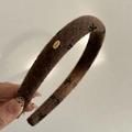 Close-up of brown wool headband featuring black bow patterns and a gold 'Love' metal charm - Dark Brown (Black Bow Gold Tag)