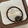 Detailed close-up of a vintage hair tie featuring an amber and green resin rose on wood - Green Tortoiseshell Flower Hair Tie