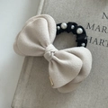 Elegante elastico per capelli in lana con fiocco e perle su sfondo di libro grigio - Bianco Sporco