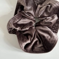 Close-up of a large French velvet scrunchie in chocolate brown with pleated texture - Deep purple
