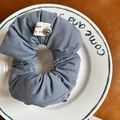 Dusty blue fabric scrunchie with silver smile charm on a decorative white porcelain plate - Blue Sponge Scrunchie (20#)