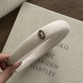 Detailed macro of vintage beige wool headband with bow logo and diagonal fabric texture - White Oval Bow
